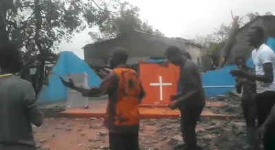 Cristãos louvam diante de igreja destruída por ciclone, em Moçambique