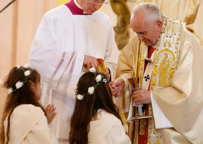 After offering instruction, pope gives first Communion to 245 children