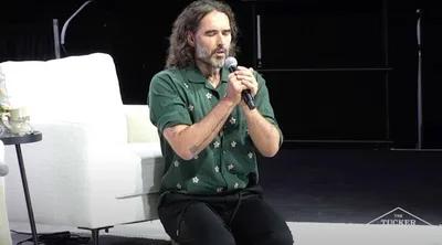 Russell Brand kneels in prayer at Tucker Carlson event, prays against 'dark and demonic ...